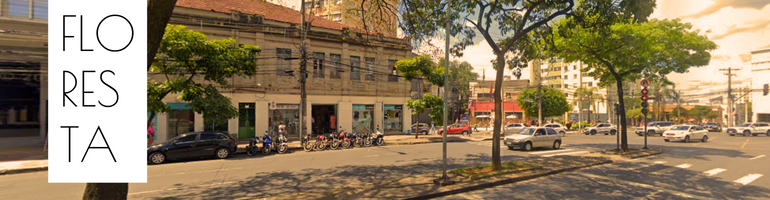 Foto da esquina da Avenida do Contorno com a Rua Curvelo no Bairro Floresta. À esquerda, a palavra FLO RES TA. Ao centro, algunas motos estacionadas e à direita alguns veículos.