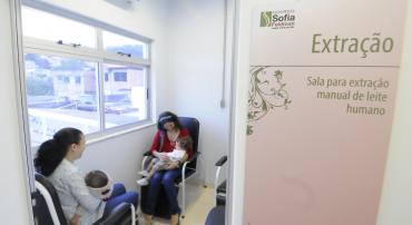 Sala de extração de leite no hospital Sofia Fieldman. Duas mães sentadas amantam seus filhos.