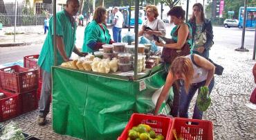 Consumidores comprando doces, frutas e hortaliças no Programa Direto da Roça