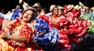Mulheres vestidas com trajes típicos juninos dançam 