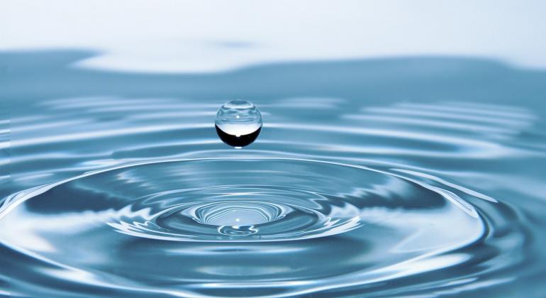 Gota d'água em destaque em imagem de água límpida