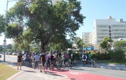 cerca de vinte ciclistas em ciclofaixa às margens do Rio Arrudas