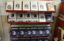 Prateleira com cerca de vinte e cinco livros, de diversos modelos, sobre Anne Frank