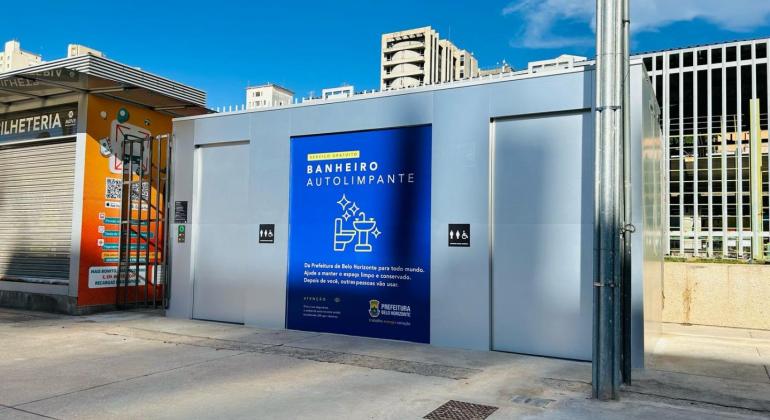 PBH registra mais de 900 mil utilizações de banheiros autolimpantes e mantém luta contra o vandalismo de estruturas Estrutura retangular, metálica, na cor cinza, com uma porta no lado esquerdo. Painel azul de identificação no centro, com a legenda "Banheiro Autolimpante" seguida de desenho gráfico - sanitário e lavabo. Outra porta ao lado direito.