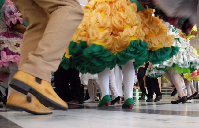 Foto mostra detalhe dos pés de pessoas dançando quadrilha