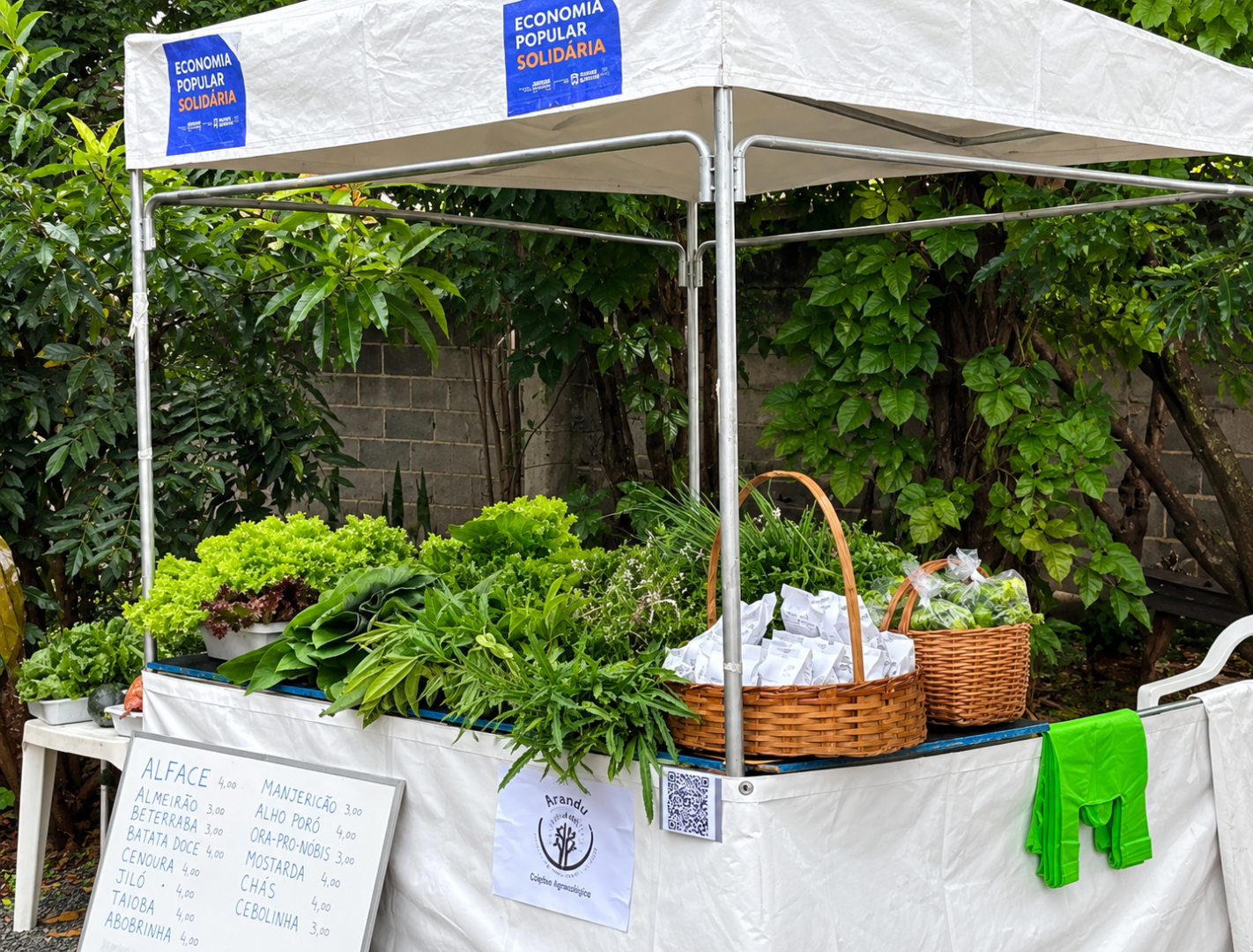 Feira no Centro Municipal de Agroecologia terá programação para toda a família neste sábado (12) Barraca de feira agroecológica com hortaliças frescas, verduras e produtos artesanais, em iniciativa de economia popular solidária.