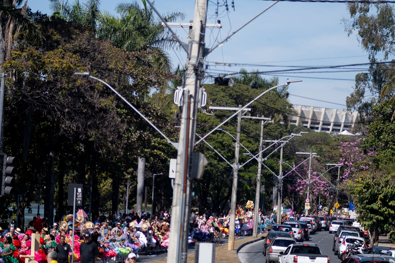 Centenas de pessoas desfilam pela Pampulha no Cortejo Junino. Elas vestem roupas típicas de quadrilha