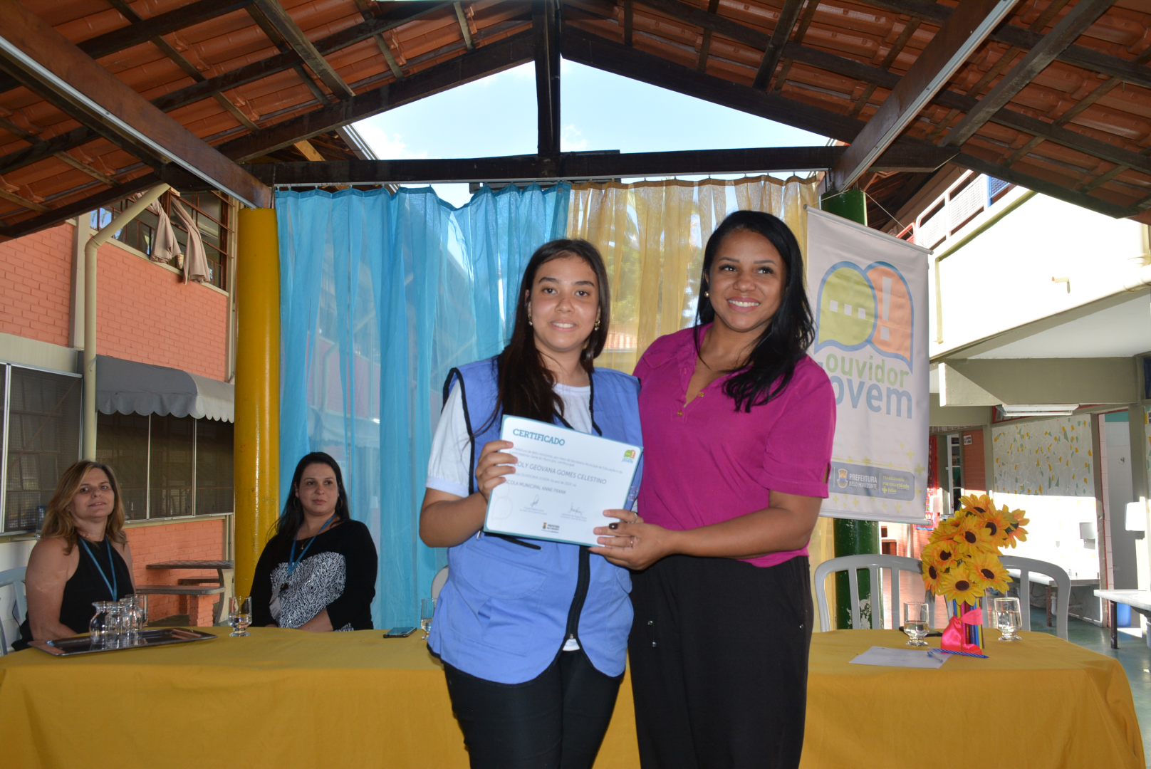 Foto da ouvidora jovem recebendo o certificado