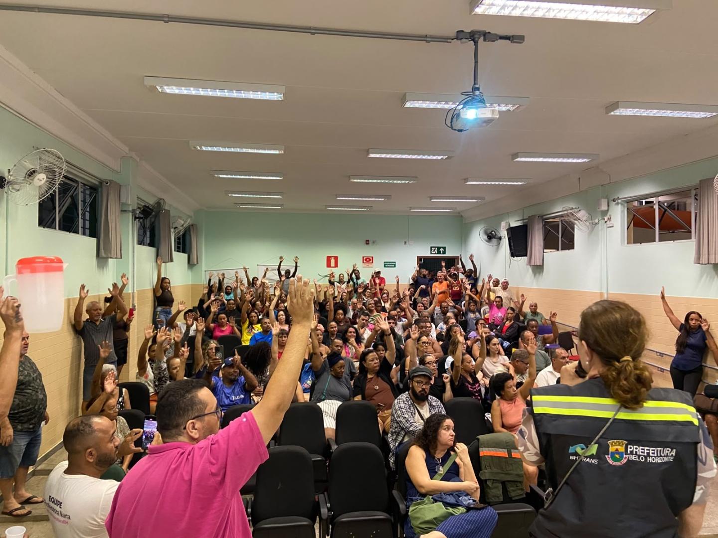 Propostas de alterações de circulação de vias e em linha de ônibus serão apresentadas às Comissões Regionais de Trânsito e Transporte Reunião em um auditório, com moradores, membros das Comissões Regionais de Trânsito e Transporte e equipe técnica da PBH. A imagem mostra momento de votação das propostas