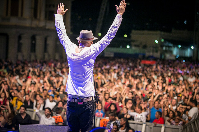 Homem em cima de um palco agradece ao público