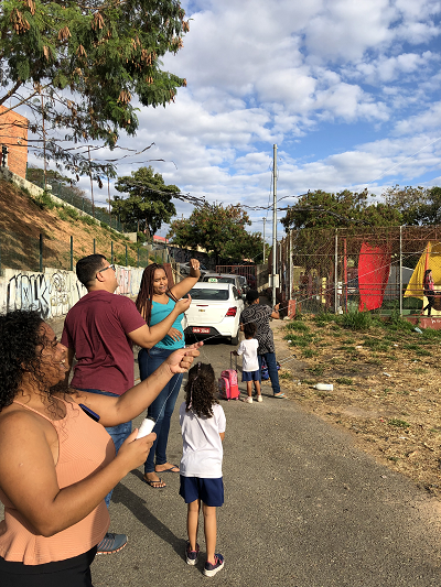 #paratodosverem Descrição: fotografia colorida de alunos(as) da Emei Jardim Guanabara junto com familiares empinando pipas.