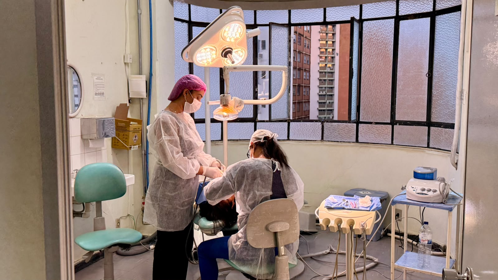 PBH nomeia 120 profissionais para reforçar atendimento nas unidades de saúde Profissionais de saúde realizam atendimento odontológico em consultório equipado, utilizando materiais de proteção individual e instrumentos específicos para o procedimento.