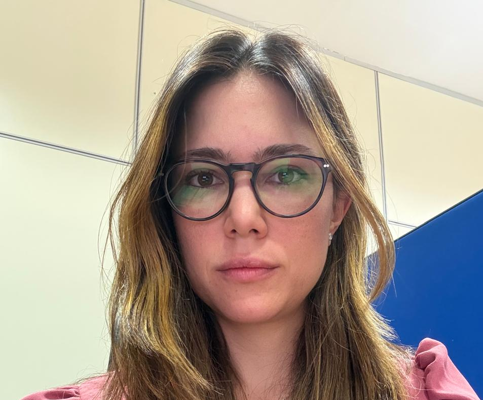 Mulher branca, usando óculos de grau, cabelos escuros com mechas loiras