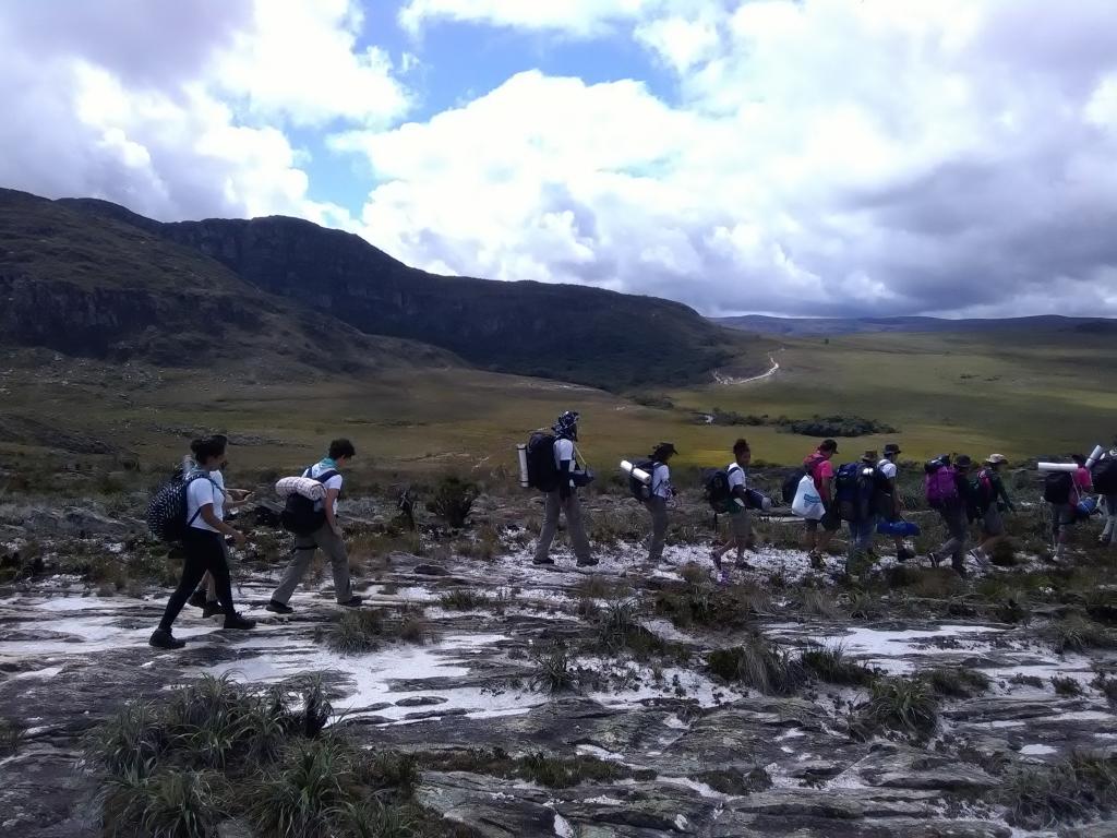 Grupo de escoteiros caminha em região montanhosa