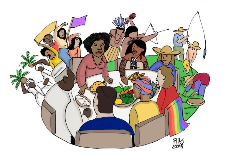 Imagem da Conferência Nacional de Segurança Alimentar e Cidadania. Uma mesa composta por uma mulher negra de pé, sentados um homem negro, uma índia, uma camponesa, uma mulher com uma bandeira LGBT, um homem branco e uma mulher de turbate estão ao redor da mesa. Há, ao lado, pescadores e indígenas na imagem.