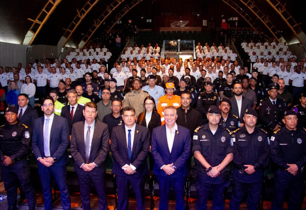 Foto oficial reúne autoridades, representantes das forças de segurança, Defesa Civil e demais participantes durante evento realizado em auditório.