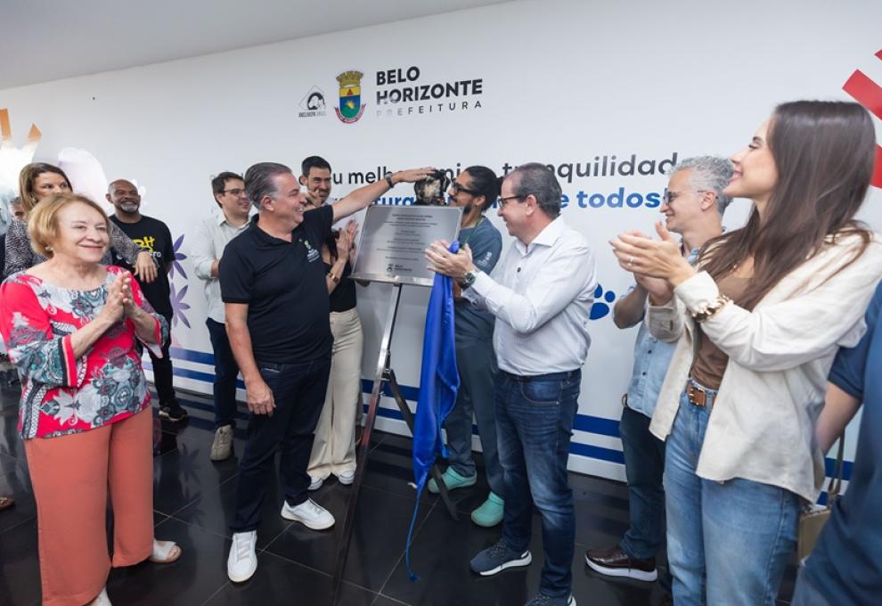 Foto do prefeito Álvaro Damião descerrando a placa de inauguração do Casa, com um cachorro ao fundo.