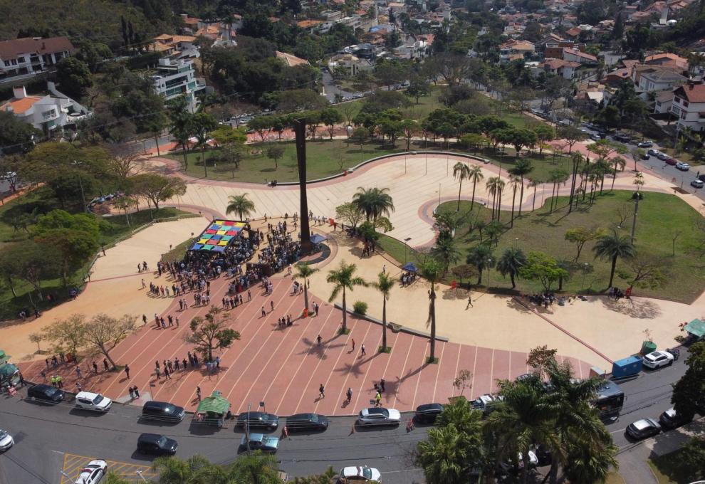 Imagem aérea mostra a Praça durante a inauguração com concentração de pessoas em torno do marco princiál.