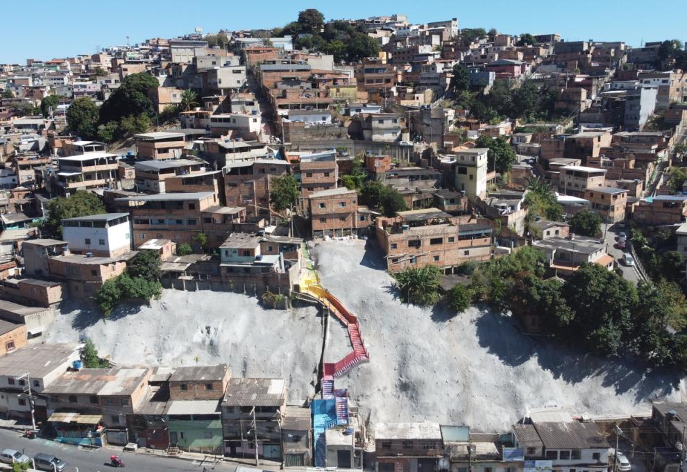 Imagem aérea da vista parcial do Alto Vera Cruz, com imóveis, muro de contenção de encosta e uma escada de acesso à comunidade.