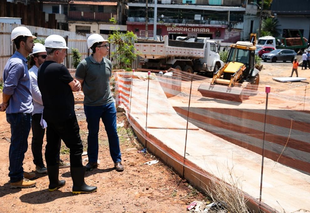 https://prefeitura.pbh.gov.br/noticias/prefeitura-de-bh-retoma-obras-de-macrodrenagem-da-praca-das-aguas-para-ampliar-protecao Foto do prefeito Álvaro Damião e outros servidores municipais usando capacete de proteção, em visita ao canteiro de obras da Praça das Águas