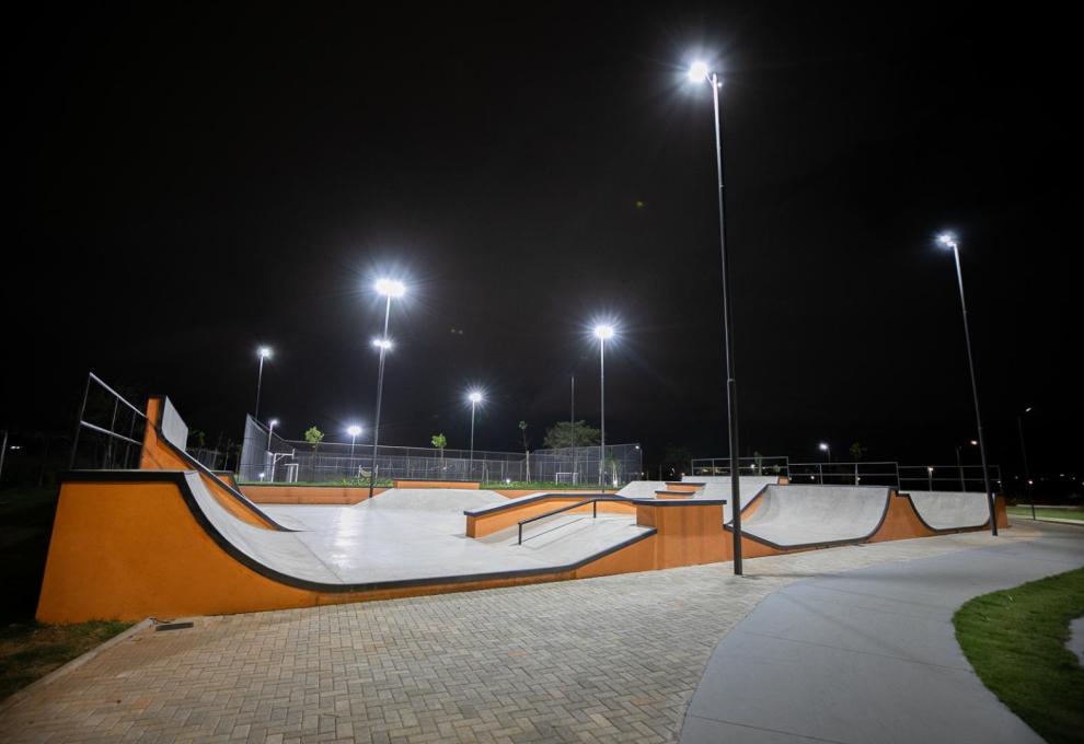 Ilumina BH completa um ano de ampliação da iluminação pública garantindo mais conforto e segurança em praças, parques e áreas verdes Visão noturna de uma pista de skate ao ar livre, vazia, com rampas de concreto cinza e detalhes laranjas. Vários postes altos iluminam fortemente o local