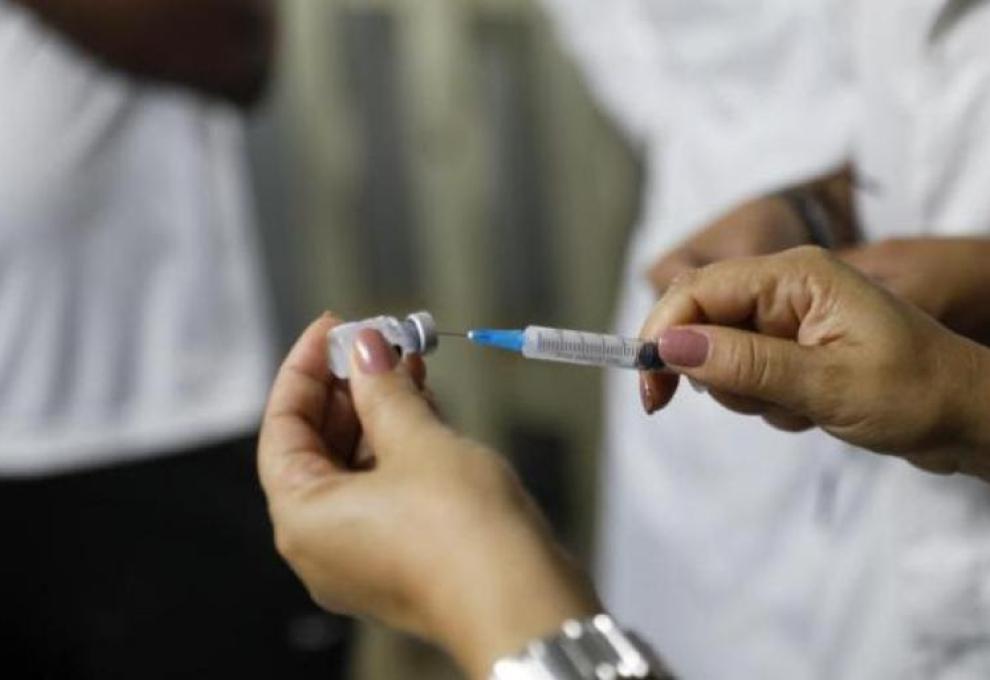 Vacinação de gestantes contra o VSR contribui para queda nas internações de bebês em BH Duas mãos segurando uma injeção e uma ampola de vacina
