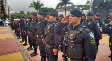 Mais de vinte membros da Guarda Municipal em formação e prestando continência. 
