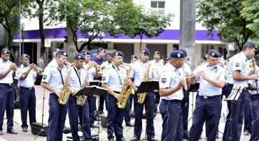 Cerca de treze Guardas municipais tocam instrumentos musicais variados ao ar livre durante o dia. Foto: Divulgação