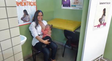 Mulher amamenta com filho no colo em Unidade de coleta de leite humano no Centro de Saúde Venda Nova