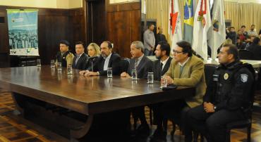 Autoridades municipais, militares e civis reunidos em mesa para concessão de entrevista coletiva