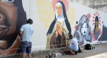 Artistas grafitam muro em área da região Leste de Belo Horizonte. Primeira obra traz Santa Tereza, Padroeira do bairro