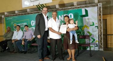 O prefeito de Belo Horizonte, Alexandre Kalil; entrega título de propriedade a família com pai, mãe e filha na Vila Pinho.