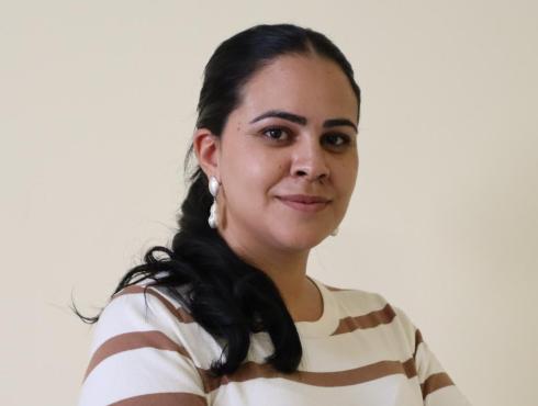 Subsecretária de Gestão Financeira e Investimentos da Educação posa para foto com cabelo pretos e bula branca com listras marrons