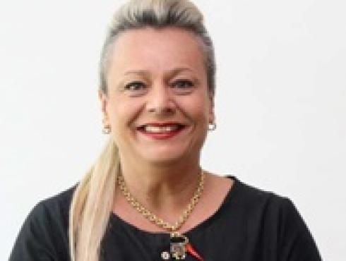 Secretária Municipal - Esportes e Lazer - Adriana Branco Cerqueira, posa em uma fotografia com uma blusa com tom escuro.