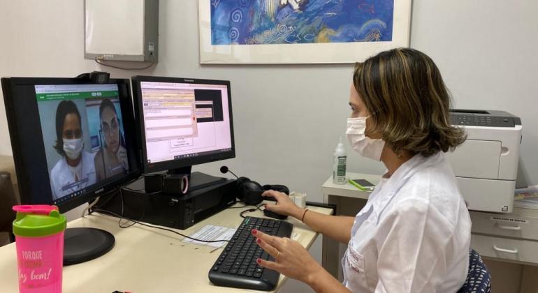 Médica em consulta virtual no computador