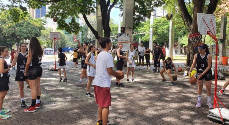 Adolescentes e crianças praticando esportes na rua