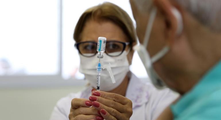PBH reforça convocação para 4ª dose da vacina de Covid para maiores de 40 anos Profissional da saúde manuseando vacina