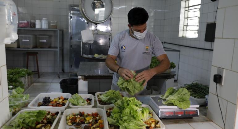 Produção de alimentos no Zoo BH garante variedade e qualidade para os animais Homem preparando as refeições dos animais