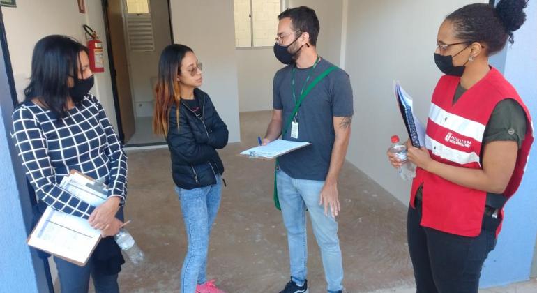 Comerciantes do Aglomerado Santa Lúcia são beneficiados com imóveis do Programa de Realocação de Atividade Comercial Moradores conversando com responsáveis da PBH