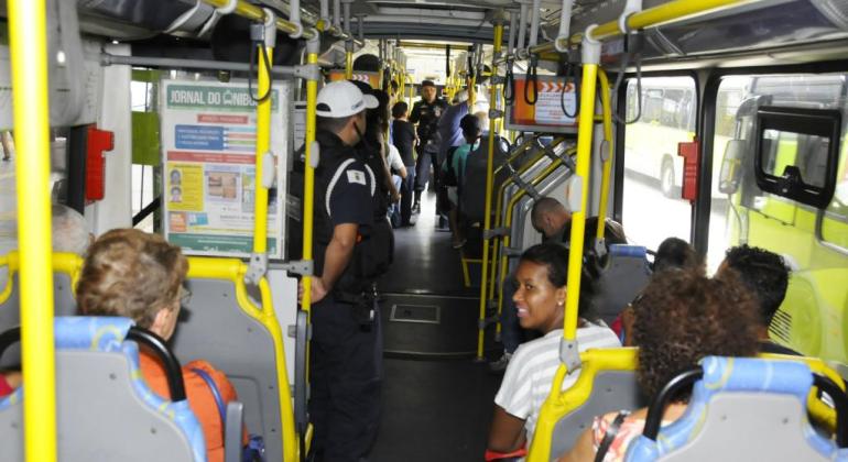 Ônibus com passageiros e guardas