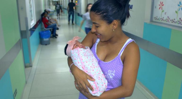 Mãe segurando a filha no Hospital Odilon Behrens