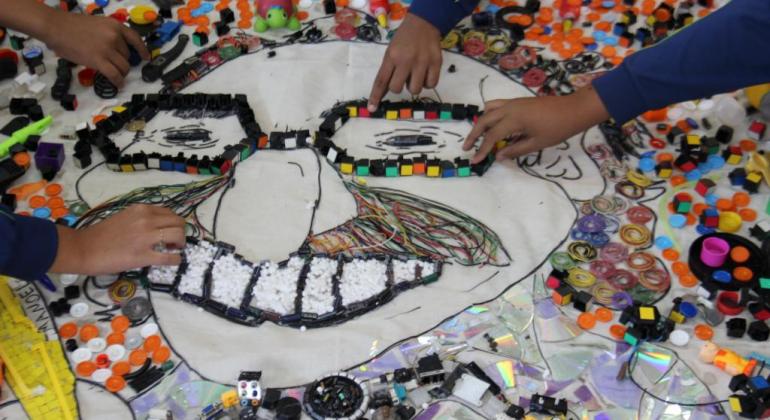 Alunos da Escola Prefeito Souza Lima transformando objetos inutilizados em obras de arte. 
