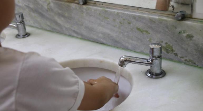 Criança lavando as mãos