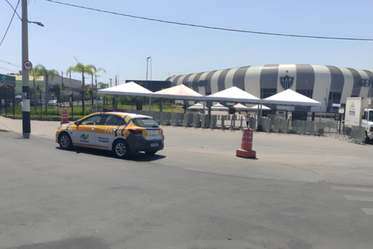 Show Djavanear conta com linha especial de ônibus na Arena MRV, neste sábado (18) Um carro da BHTrans, empresa que cuida do trânsito em BH, estacionado próximo à calçada da Arena MRV. O estádio do Atlético está ao fundo e tem a fachada em listas nas cores branca e cinza.