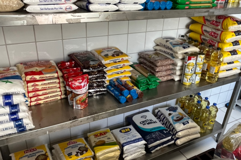 prateleiras de metal com diversos sacos de alimentos empilhados 