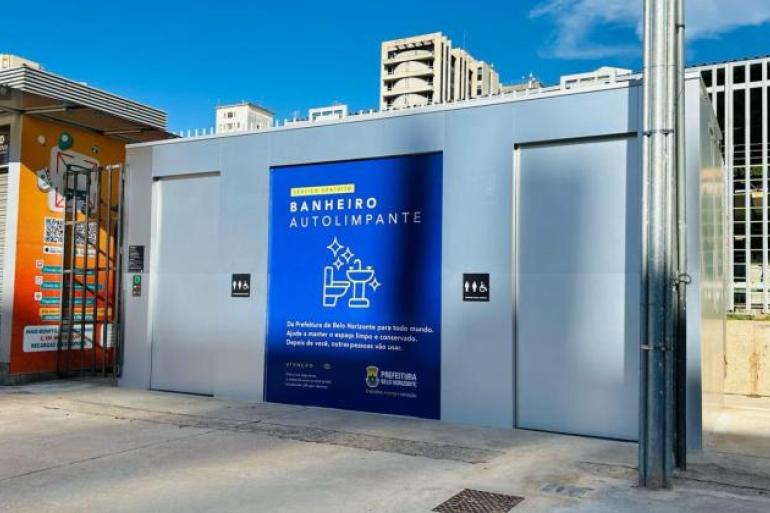 PBH registra mais de 900 mil utilizações de banheiros autolimpantes e mantém luta contra o vandalismo de estruturas Estrutura retangular, metálica, na cor cinza, com uma porta no lado esquerdo. Painel azul de identificação no centro, com a legenda "Banheiro Autolimpante" seguida de desenho gráfico - sanitário e lavabo. Outra porta ao lado direito.