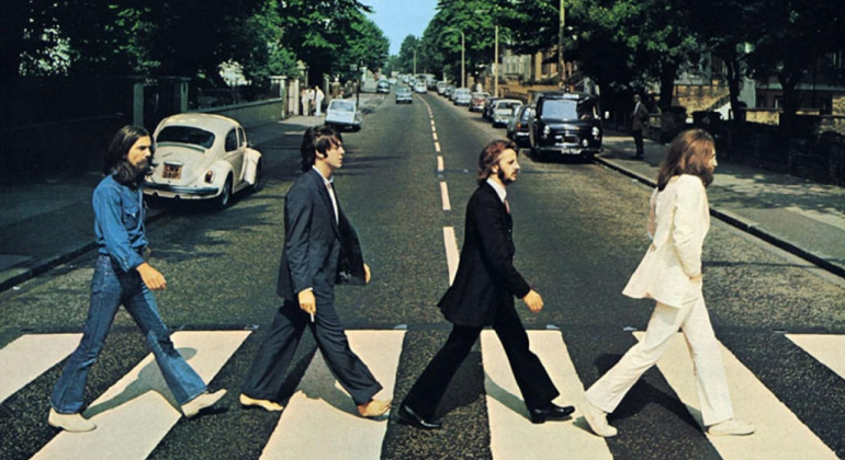 Quatro integrandes da banda Beatles andam na Abbey Road, em Londres.