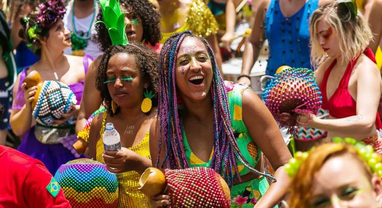 Integrantes de bloco de rua, usando as fantasias de abacaxi, segurado instrumentos de percussão 