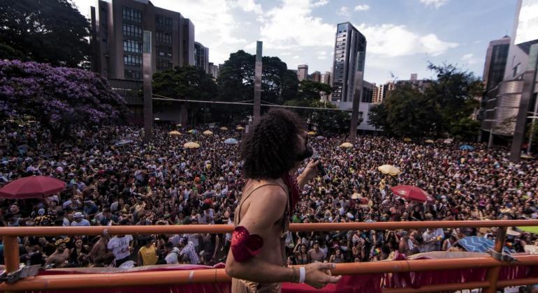 Cantor se apresenta em trio elétrico; ao fundo mais de tresentas pessos o acompanham, em algum ponto da cidade de Belo Horizonte, durante o dia.