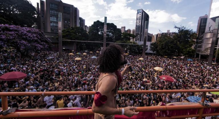 O edital de Parcerias para empresas interessadas em apoiar o Carnaval 2019 foi lançado pela Belotour no dia 26/1. Foto: Divulgação PBH homem canta em cima de trio elétrico; embaixo, mais de trezentas pessoas pulam carnaval, durante o dia.